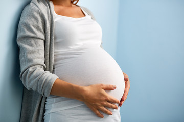 Schwangere Frau, die den Babybauch umfasst